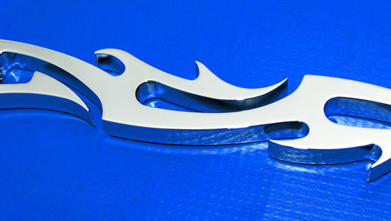 Chrome billet shift link with end bolts. Tribal flames and skulls design. 2 inches over stock length. Skulls detail.